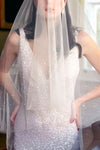 A model wearing VIVIENNE, a drop veil with pearls and crystals by Madame Tulle