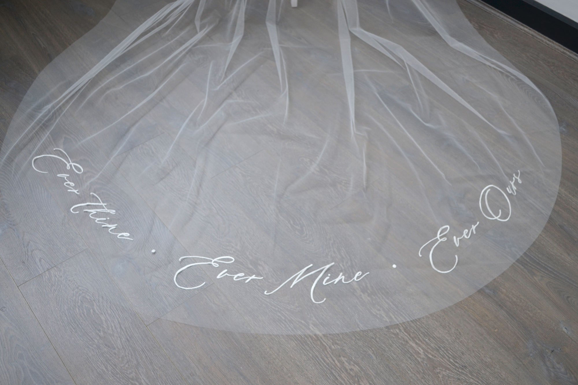 A wedding veil with embroidery text ever thine, ever mine, ever ours
