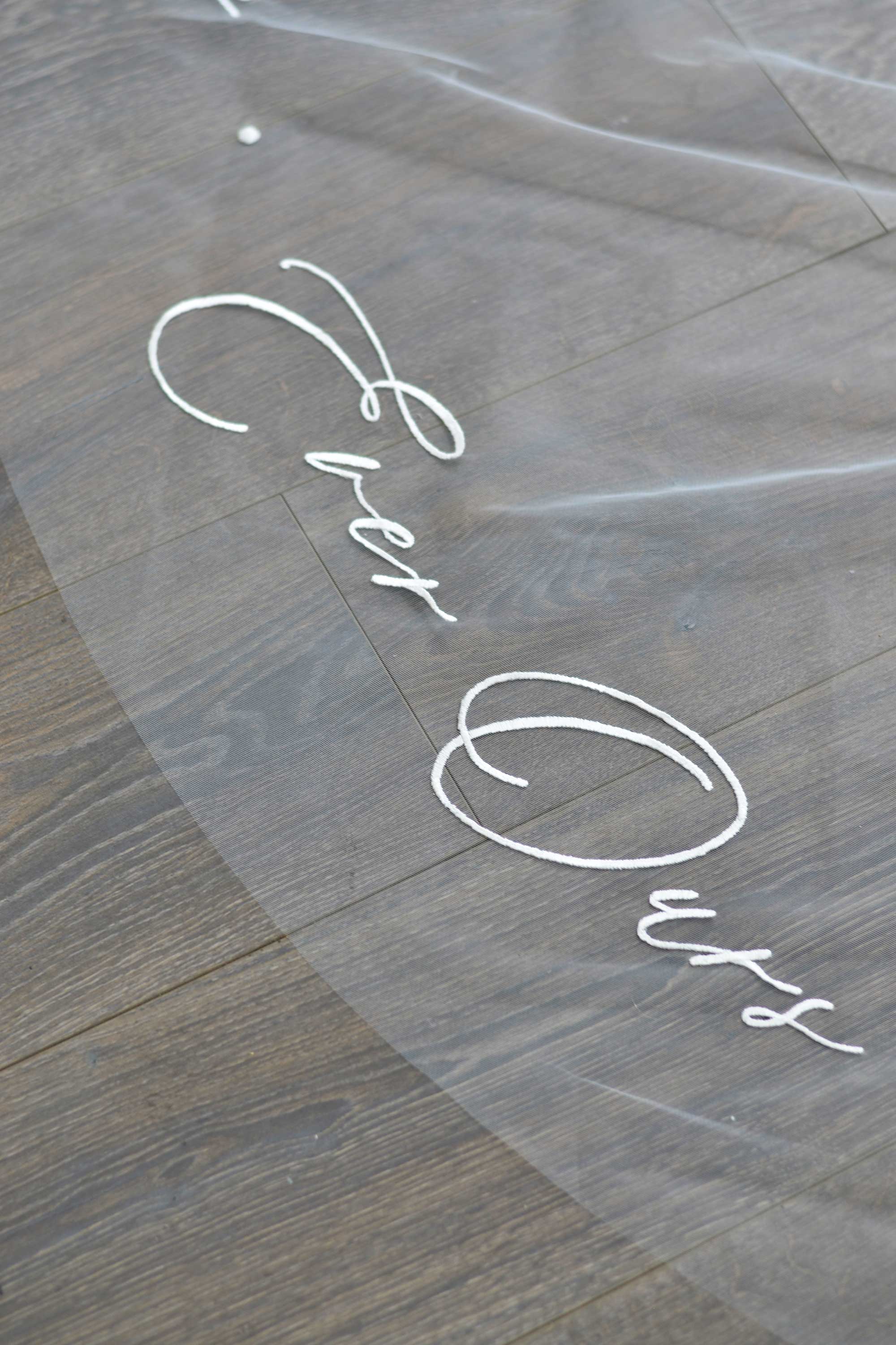 A wedding veil with embroidery text ever thine, ever mine, ever ours