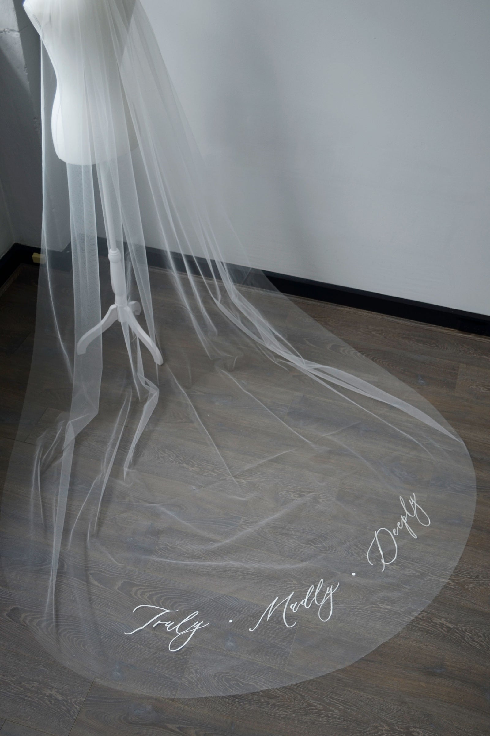 A wedding veil with embroidery text Truly • Madly • Deeply