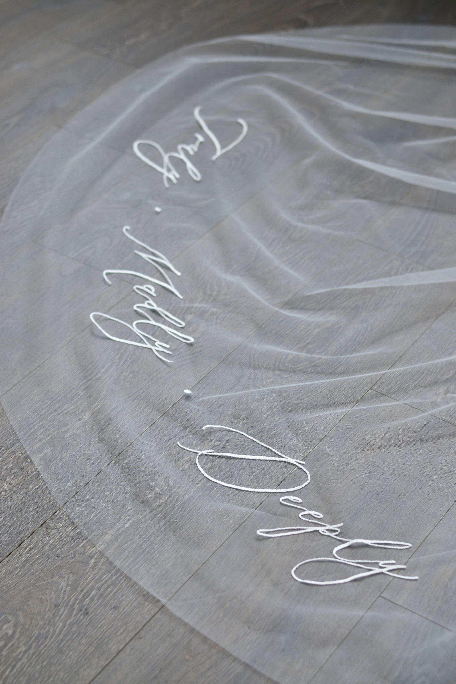 A wedding veil with embroidery text Truly • Madly • Deeply