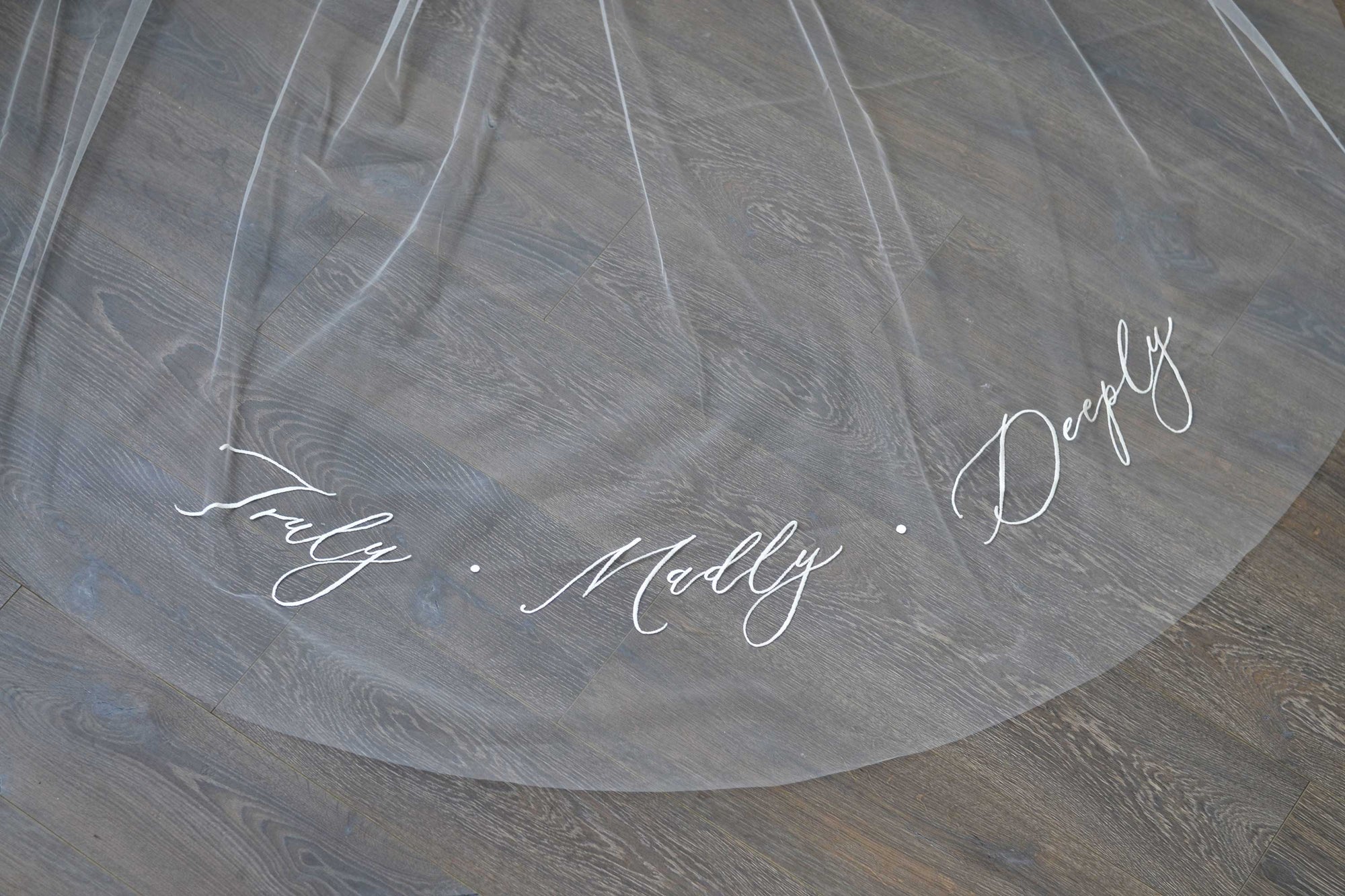 A wedding veil with embroidery text Truly • Madly • Deeply