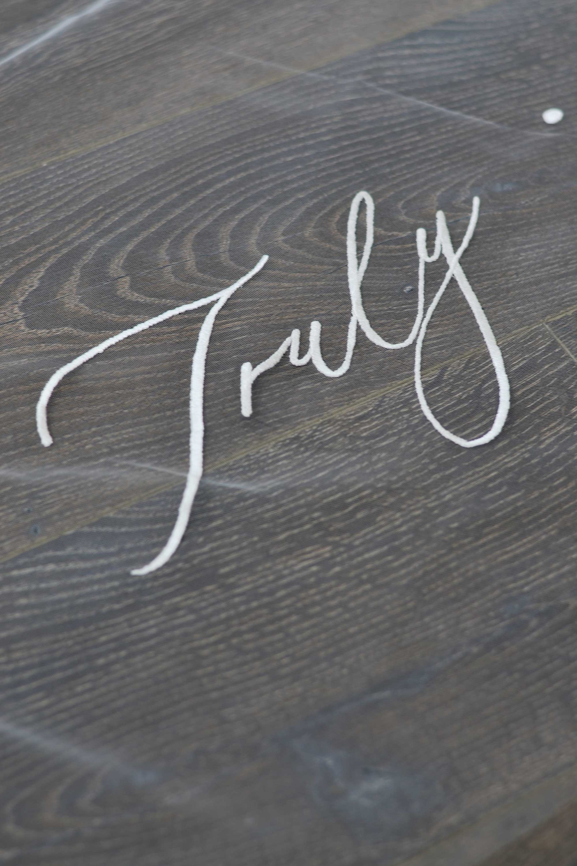 A wedding veil with embroidery text Truly • Madly • Deeply