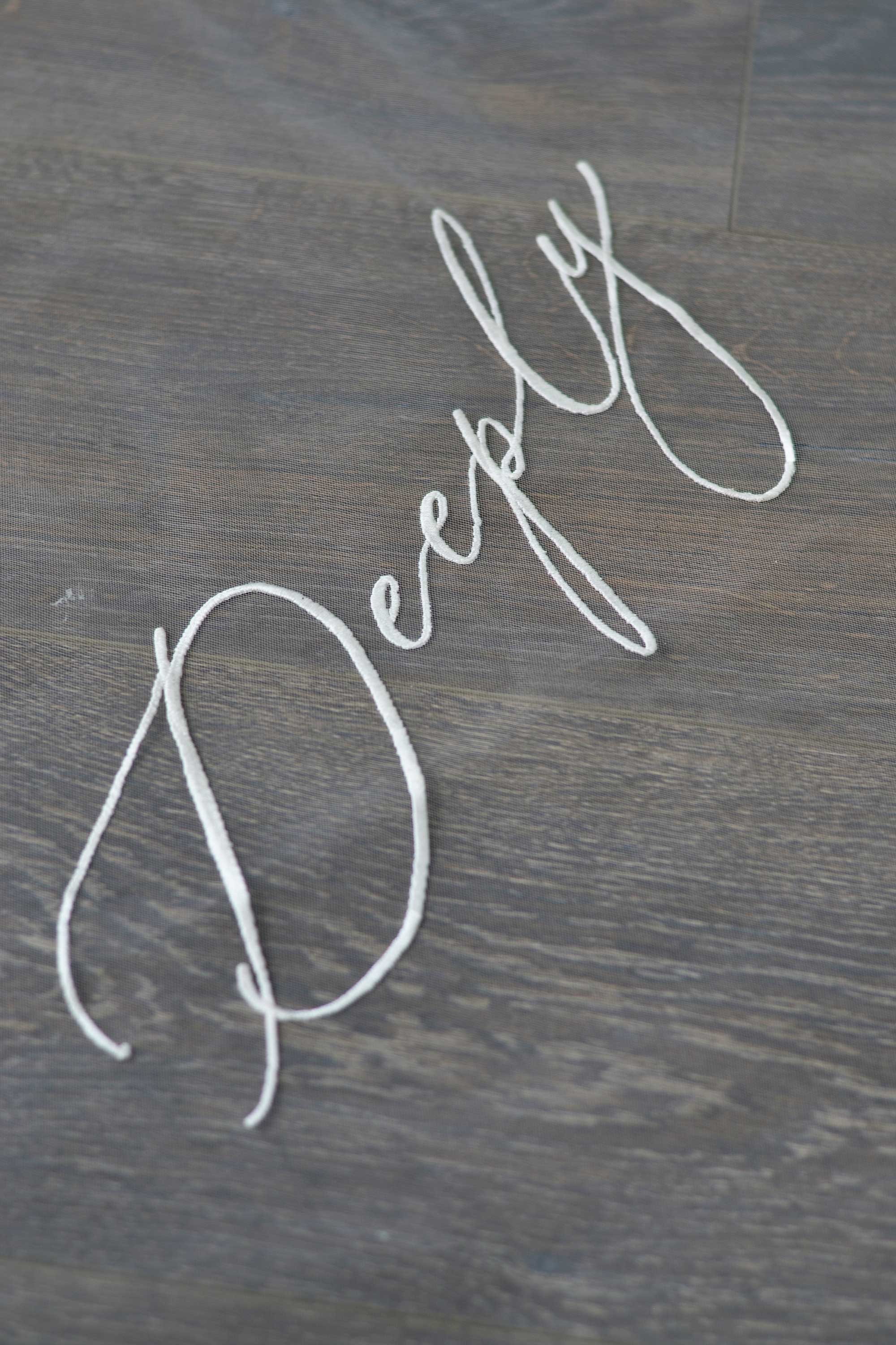 A wedding veil with embroidery text Truly • Madly • Deeply